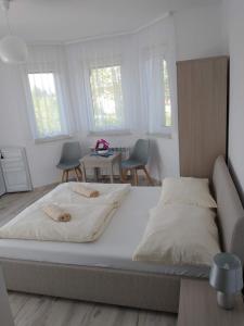 a bedroom with a large bed and a table at Bożenka in Niechorze