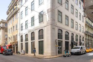 un homme marchant dans une rue devant un bâtiment dans l'établissement Ando Living - Douradores Townhouse, à Lisbonne