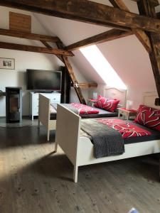 a attic bedroom with two beds and a flat screen tv at Apartment Maria in Kürten