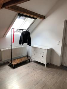 a attic room with a dresser and a window at Apartment Maria in Kürten