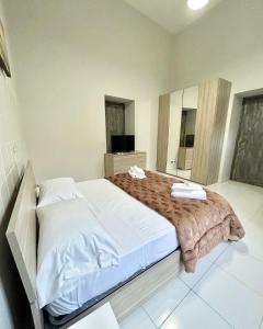 a bedroom with a large bed with white sheets at B&B VALENTINO NAPOLI in Naples