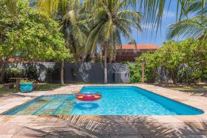 a swimming pool with a red boat in it at Casa Dunas - Espaço e Conforto em PDD by Carpediem in Aquiraz