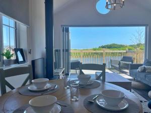 a dining room table with dishes on top of it at Lakeside Retreat, The Bay Filey, 2 bedrooms with ensuites, parking with EV charger in Filey