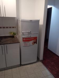 a kitchen with a refrigerator with a magazine on it at Departamento Centro in San Fernando del Valle de Catamarca