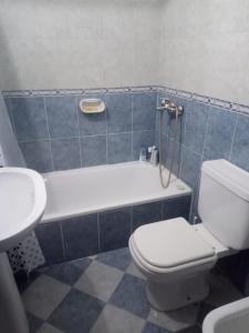 W łazience znajduje się toaleta, wanna i umywalka. w obiekcie Departamento Centro w mieście San Fernando del Valle de Catamarca