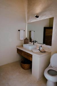a bathroom with a sink and a toilet and a mirror at Casa De Amigos Hotel Boutique in Honda