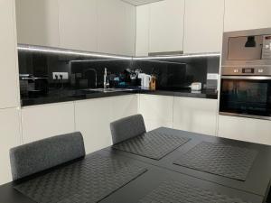 a kitchen with a table and two chairs and a microwave at Supertubos - Peniche - Consolação in Peniche