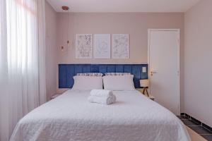 a bedroom with a large white bed with towels on it at Casa Dunas - Espaço e Conforto em PDD by Carpediem in Aquiraz