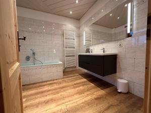 y baño con bañera y lavamanos. en Ferienhaus "Kleines Domizil" Altenberg - direkt im Zentrum von Altenberg gegenüber vom Skilift en Kurort Altenberg