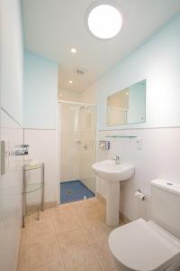 箭鎮的住宿－阿羅敦夜色酒店，浴室配有卫生间、盥洗盆和淋浴。