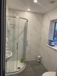 a bathroom with a glass shower and a sink at London Studios in BR54LT in Saint Mary Cray