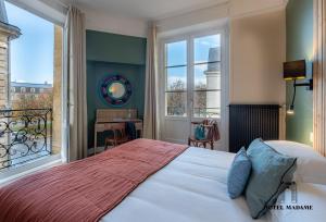 - une chambre avec un lit et une grande fenêtre dans l'établissement Hôtel Madame, à Bordeaux