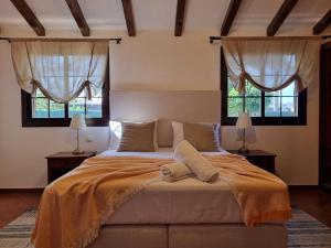 um quarto com uma cama grande e 2 janelas em Surf&fun heated pool villa em La Oliva