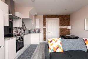 a kitchen and living room with white cabinets and a couch at Summer stays for Grain LNG contractors - Apartment D in Gillingham