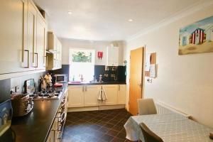 een keuken met witte kasten en een aanrechtblad bij Gerald's Place in Deal +25 foto's