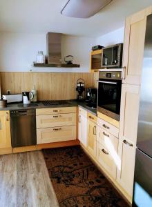 una cocina con armarios de madera y electrodomésticos de acero inoxidable en Casa „Ella“, en Friedrichroda