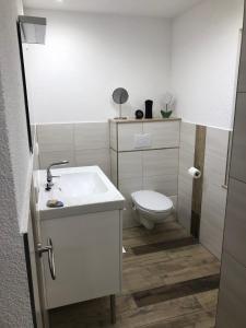 a bathroom with a white sink and a toilet at Casa „Ella“ in Friedrichroda