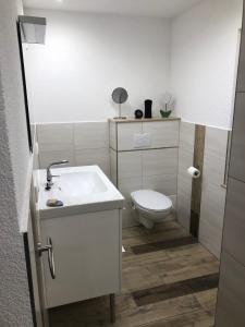 a bathroom with a white sink and a toilet at Casa „Ella“ in Friedrichroda +27 photos