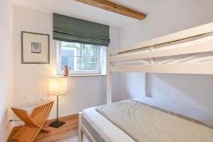 a bedroom with a bed and a lamp and a chair at Im Allgäuer Bauernstall in Nesselwang