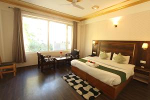 a bedroom with a bed and a table and a window at Hotel NSB Manali in Manāli +28 photos