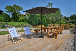 a table and chairs and an umbrella on a deck at Im Allgäuer Bauernstall in Nesselwang