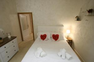 a bedroom with a white bed with two hearts on it at Colosseum apartment in Rome