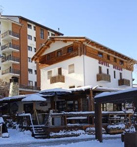 ein Hotel mit Schnee auf dem Boden vor einem Gebäude in der Unterkunft Hotel Derby Bar in Sauze dʼOulx
