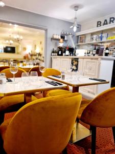 un restaurant avec des tables et des chaises et des verres à vin. dans l'établissement Hôtel Caravelle Contact Hôtel, à Rochefort