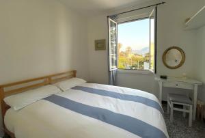 Un dormitorio con una cama azul y blanca y una ventana en Sea Home above Sori village, en Sori