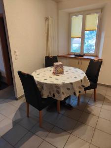 una mesa de comedor con sillas y una bolsa. en Studio Dante en Le Noirmont