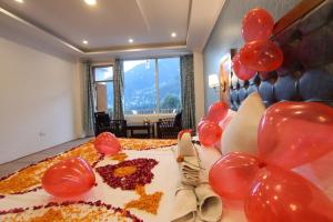 a large birthday cake with red balloons on top of it at Hotel NSB Manali in Manāli