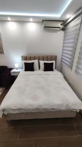 um quarto com uma grande cama branca e 2 almofadas em Apartman Vivaldi - CENTAR em Vrnjačka Banja