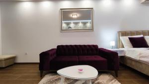 uma sala de estar com um sofá e uma cama em Apartman Vivaldi - CENTAR em Vrnjačka Banja