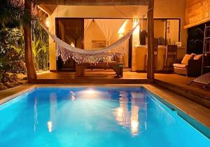 a swimming pool with a hammock in a living room at Villas Argan - Paradise Gateway in Santa Teresa Beach