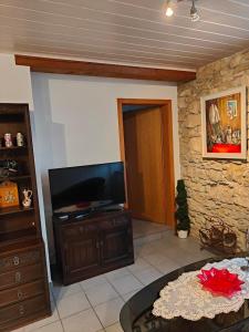 a living room with a tv and a table at Studio Dante in Le Noirmont