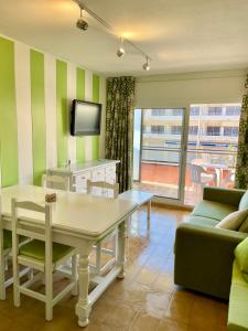 een woonkamer met een tafel en een tv bij ALMA BEACH ESTARTIT in L'Estartit