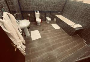 uma casa de banho com um lavatório, uma banheira e um WC. em Hotel la renaissance tata em Tatta