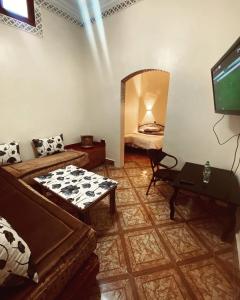 a living room with a couch and a flat screen tv at Hotel la renaissance tata in Tatta