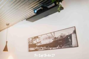 una tv appesa a un muro con una foto di una nave di The Loft Studio 57 - VUT.3352AS a Ribadesella