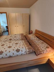 ein Bett mit einem Holzrahmen in einem Schlafzimmer in der Unterkunft Studio Dante in Le Noirmont