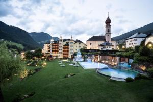 a resort with two swimming pools and a building at Adler Spa Resort Dolomiti in Ortisei