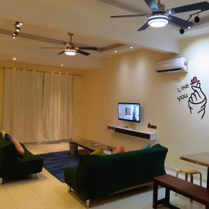 a living room with green furniture and a flat screen tv at Viens303 Home Bentong Homestay in Bentong