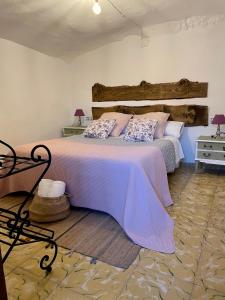 a bedroom with a large bed with a wooden headboard at Cueva de la Abuela María in Alcalá del Júcar