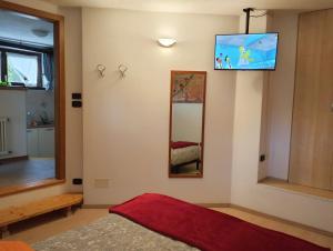a bedroom with a tv on the wall and a bed at Le Betulle in Vezzano