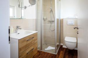 ein Bad mit einer Dusche, einem Waschbecken und einem WC in der Unterkunft Insulaner Apartments in Helgoland