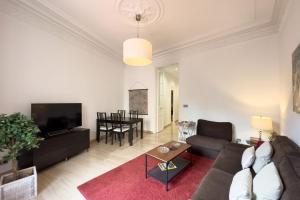 ein Wohnzimmer mit einem Sofa und einem Tisch in der Unterkunft ApartEasy - Passeig de Gracia in Barcelona