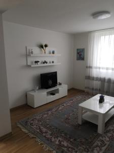 sala de estar blanca con TV y mesa en Apartman Deni en Travnik