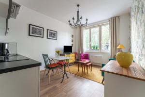 cocina y sala de estar con mesa y sillas en Les Potiers 1 - proche centre historique en Arras