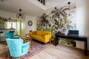 uma sala de estar com um sofá amarelo e uma secretária em Les Potiers 2 - charmant appartement en duplex em Arras
