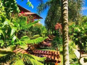 um jardim com bancos e plantas e uma casa em Eagles Nest Cabanas em Tangalle
